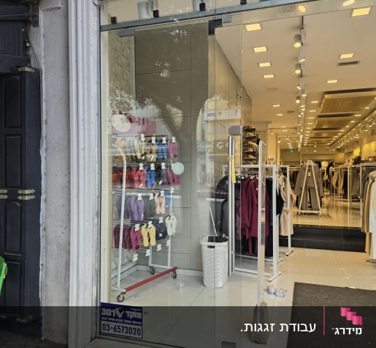חלון ראווה ודלת זכוכית בכניסה לחנות הלבשה והנעלה